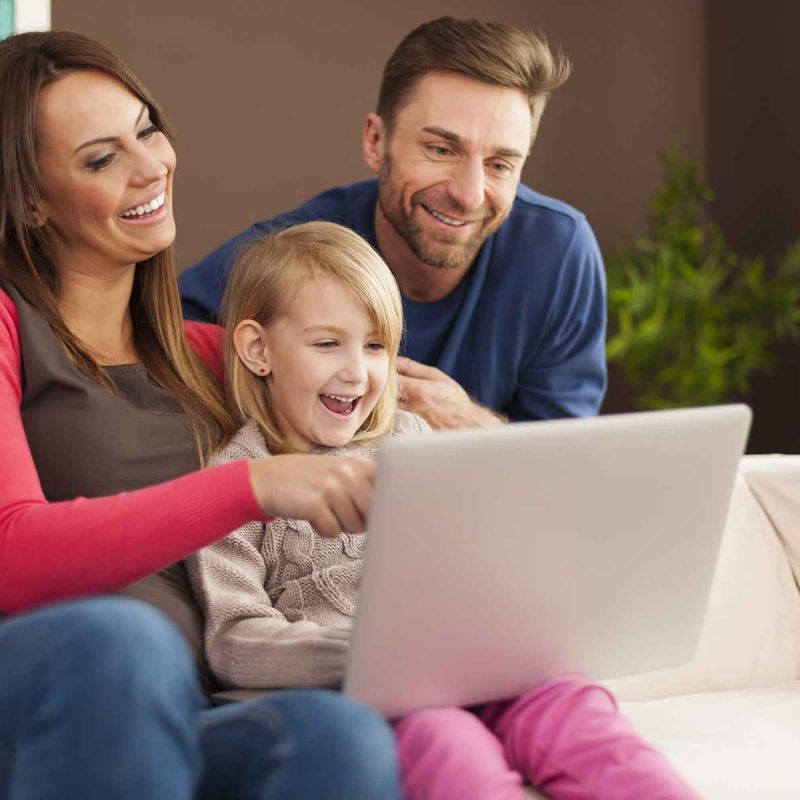 family-laughing-together-and-using-laptop-at-home-BVSVZMX-1.jpg